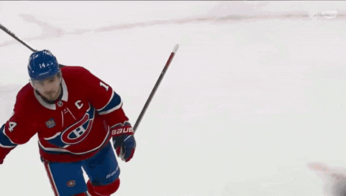 a hockey player wearing a red white and blue jersey with the letter c on it
