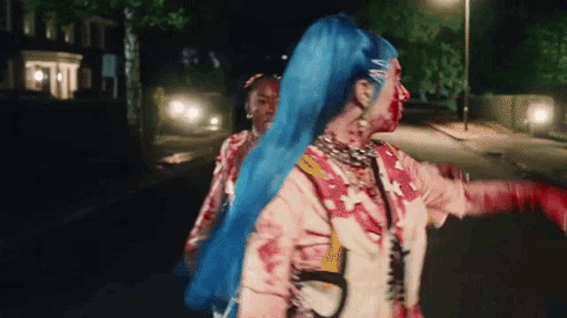 a woman with blue hair is walking down the street with another woman