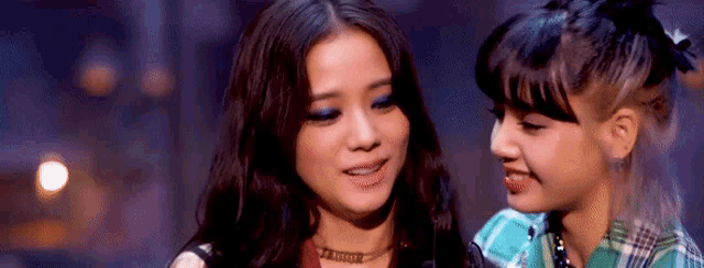 a couple of women standing next to each other and smiling .