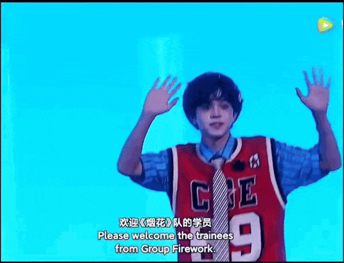 a young man in a red basketball jersey and tie is waving his hands in the air .
