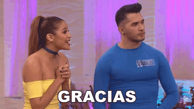 a man and a woman are standing next to each other and the man is wearing a blue gracias shirt