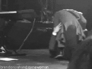 a black and white photo of a man kneeling on the floor .
