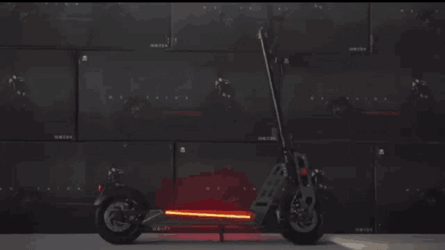 a scooter is parked in front of a wall that says origin on it