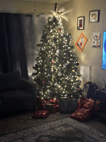a living room with a christmas tree and gifts underneath it