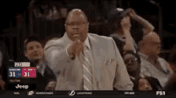 a man in a suit and tie is pointing at the camera