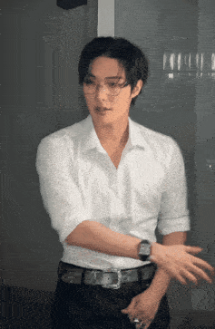 a man wearing glasses and a white shirt is standing in a room