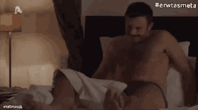 a man without a shirt is laying on a bed