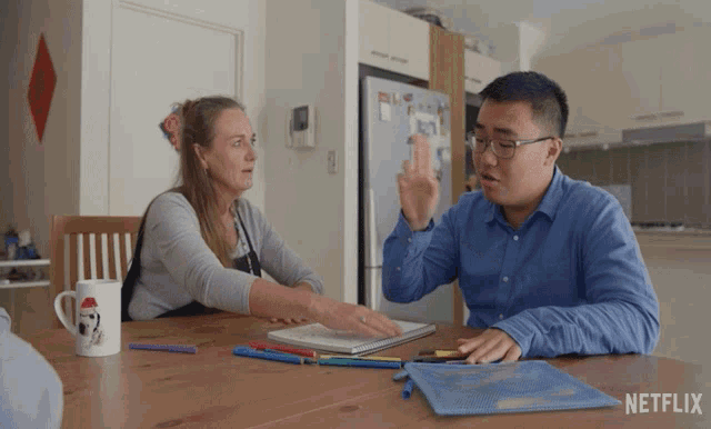 a man and a woman sit at a table with netflix written on the bottom