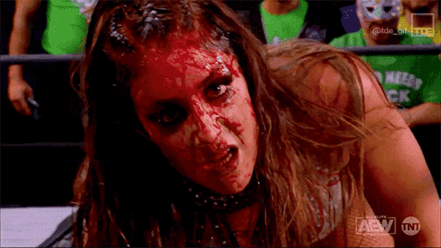 a woman with blood on her face is wearing a shirt that says tnt on it