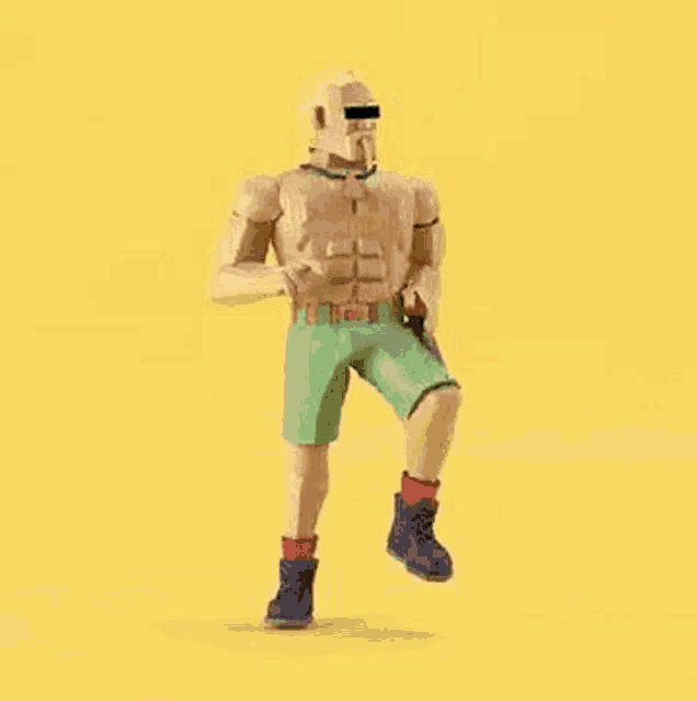 a toy figure of a man with a mustache is standing on a yellow background .