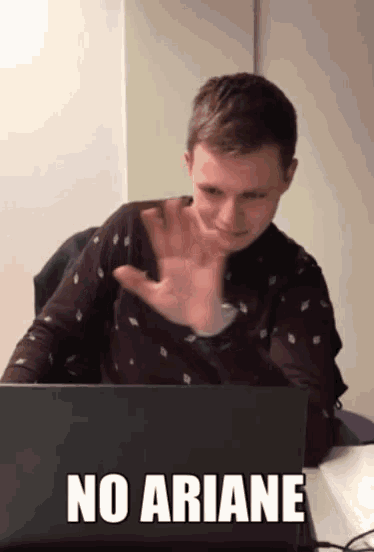 a man sitting in front of a laptop with the words " no ariane " on the bottom