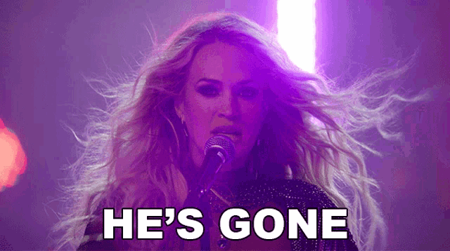 a woman singing into a microphone with the words " he 's gone " behind her