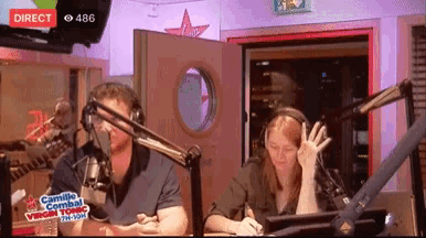 a man and a woman are sitting in front of microphones and a sign that says direct on it