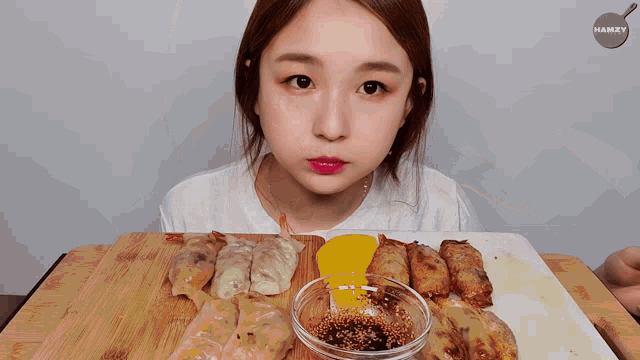 a woman eating a piece of food with hamzy on the bottom right