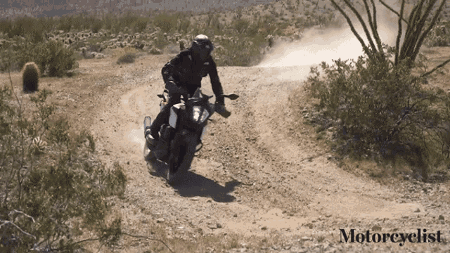 a man riding a motorcycle on a dirt road with the words motorcyclist on the bottom