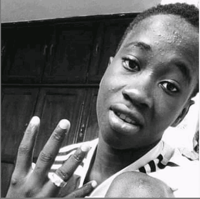 a black and white photo of a young man taking a selfie with his fingers in the air .