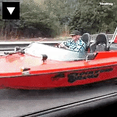 a man is driving a red speedboat with the word virahog on the bottom left
