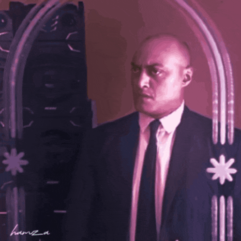 a man in a suit and tie is standing in front of a mirror with a star on it