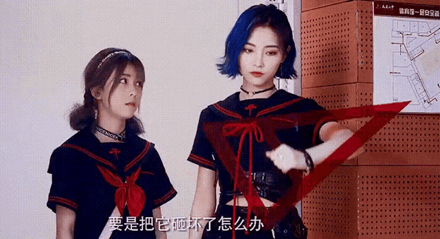 two girls are standing next to each other and one is holding a red triangle ..