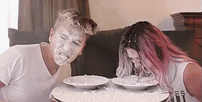 a man and a woman are sitting at a table with bowls of food .