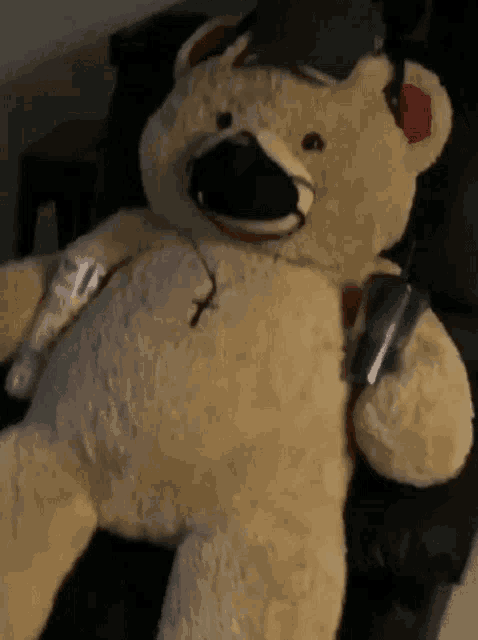 a teddy bear wearing a hat and headphones is sitting on a couch .