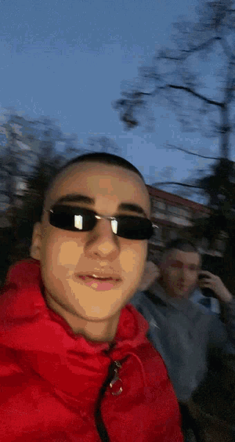 a man wearing sunglasses and a red jacket
