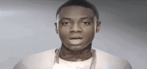 a man with a tattoo on his face is wearing a white shirt and a gold chain .