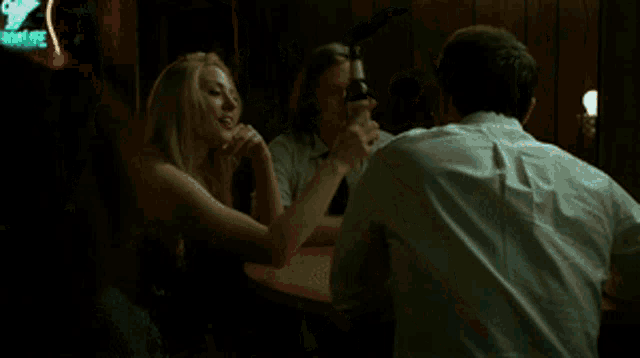 a man in a white shirt and tie is holding a bottle of alcohol