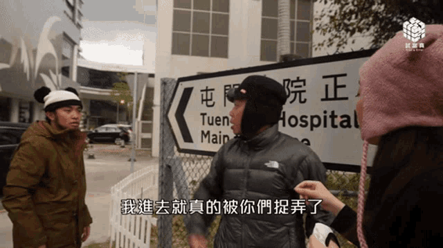 a man standing in front of a sign that says tuen main hospital