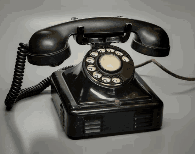 an old fashioned black telephone with the number 1 on the dial