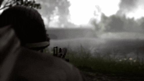 a person standing in a field with a rifle in their hand
