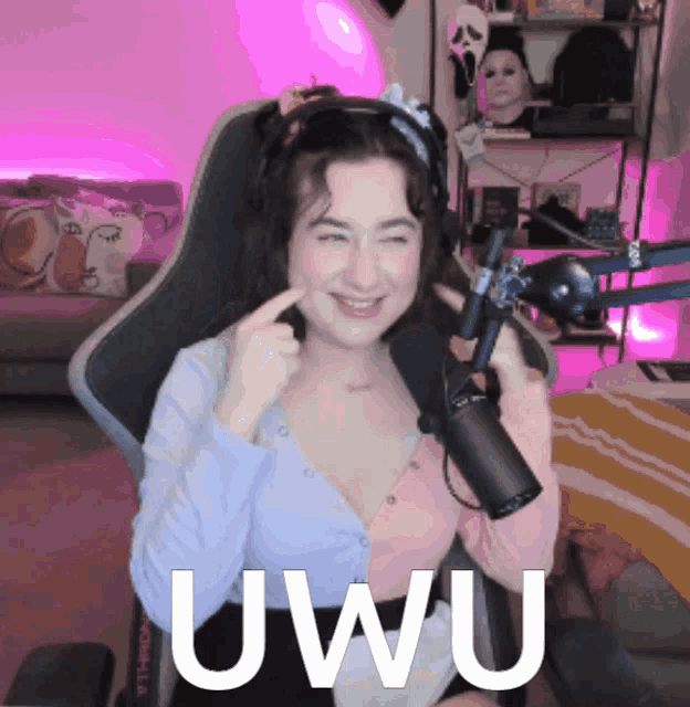 a woman is sitting in front of a microphone and the word uwu is on the bottom