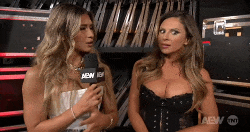two women standing next to each other with a microphone that says aew
