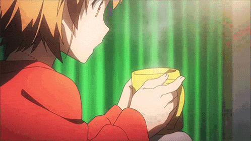 a person in a red shirt is holding a yellow mug