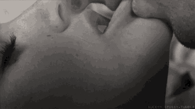 a black and white photo of a man and a woman kissing .