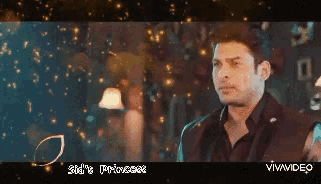a man in a black suit is standing in front of a blue background with the words sid 's princess written on it