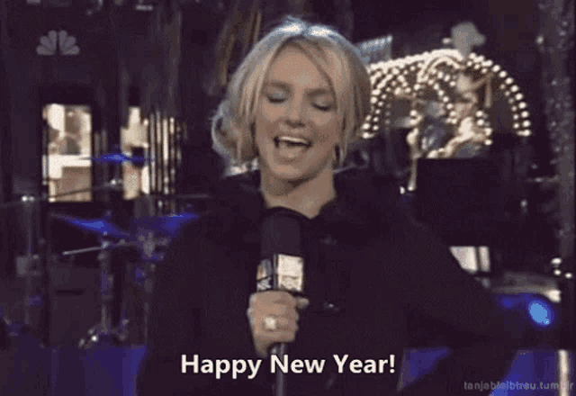 a woman holding a microphone with the words happy new year written below her
