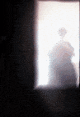 a shadow of a person is cast on a wall in a dark room