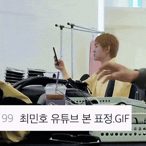 a person sitting at a table with a cup of coffee and a cell phone in their hand