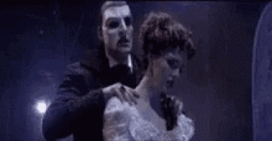 a man and a woman are dancing together in a dark room .
