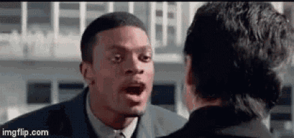 a man in a suit and tie is yelling at another man in a suit and tie .