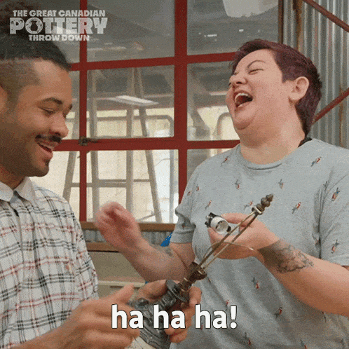 a man and a woman are laughing and the woman is holding a lamp and the man is saying ha ha ha