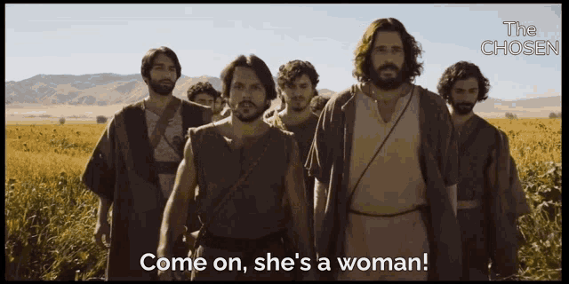 a group of men are standing in a field with the words come on she 's a woman