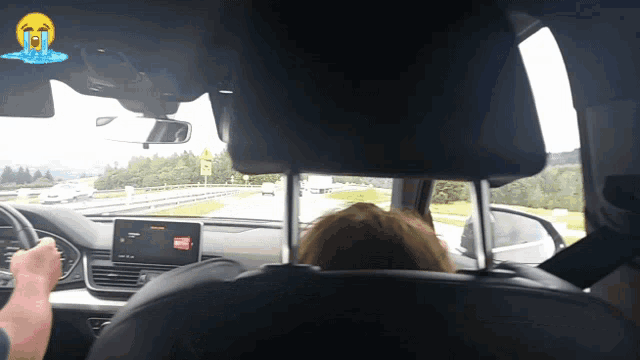 a man is driving a car with a tear coming out of his eye