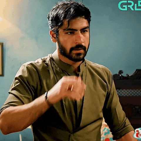 a man in a green shirt is standing in front of a blue wall with the letters grl on it