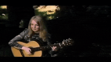 a man is playing a guitar next to a woman .