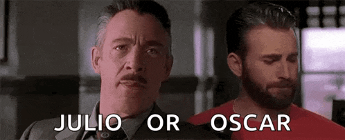 a man with a mustache and a beard is standing next to a man with a red shirt .
