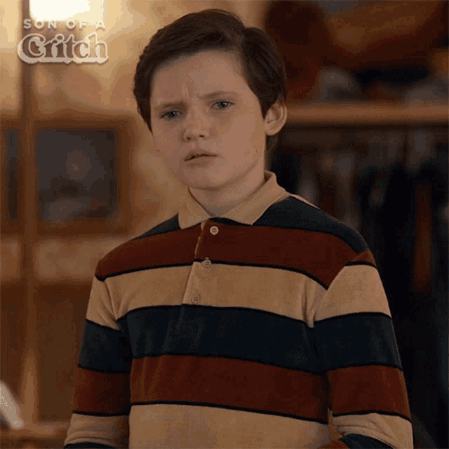 a young boy is wearing a striped shirt with the words son of a grifch behind him