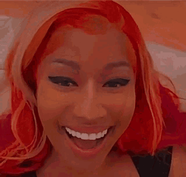 a woman with red hair is smiling for the camera while sitting in a bathtub .
