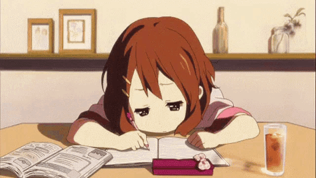 a girl is sitting at a table writing in a notebook next to a glass of tea